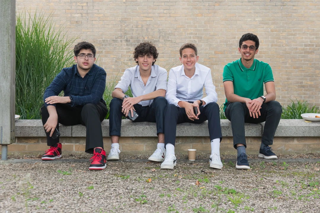 Four Business students sitting down and smiling