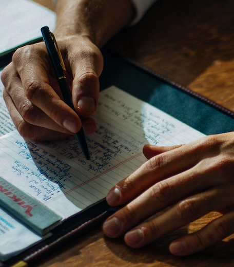 Close up photograph of a student writing in a notebook