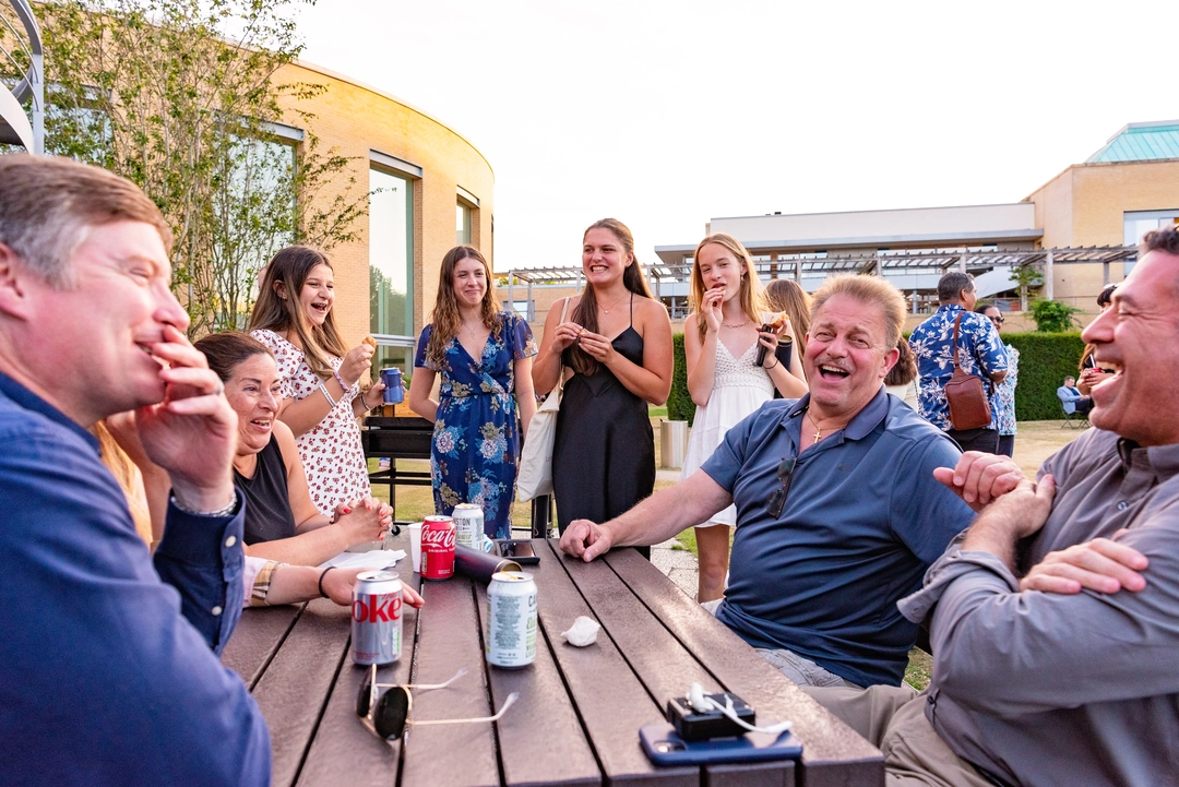 Parents and students laughing around a picnic table